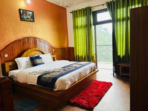 a bedroom with a bed with green curtains and a window at Hotel Sumit in Kausani