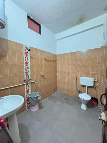 a bathroom with a toilet and a sink at Hotel Sumit in Kausani