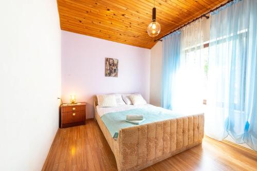 a bedroom with a bed and a large window at Apartmani Danijela in Stara Novalja