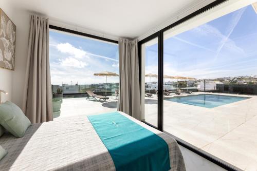 a bedroom with a bed and a view of a pool at Ocean View Lanzarote by Beyond in Tías