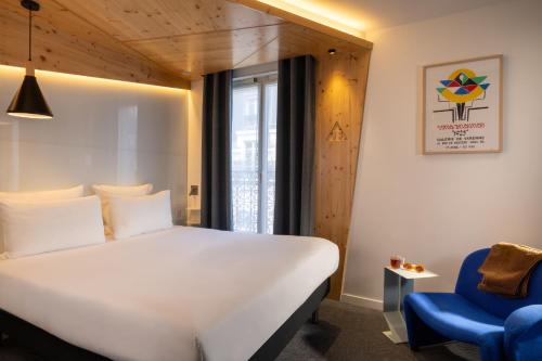 a bedroom with a white bed and a blue chair at Urban Bivouac Hotel in Paris