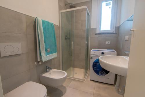 a bathroom with a shower and a toilet and a sink at Margidore Beach in Lacona