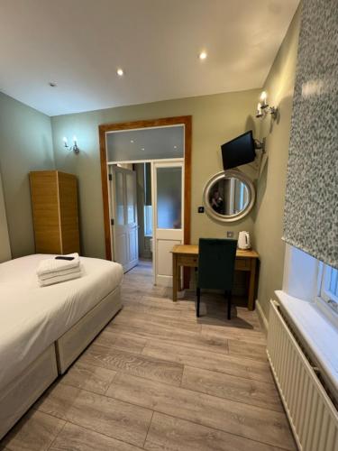 a bedroom with a bed and a desk and a mirror at The Paramount Hotel in London