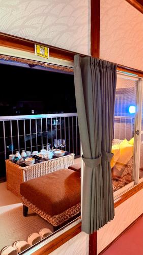 a room with a window with a bed and a table at Grace House Hill Paradise Atami in Atami