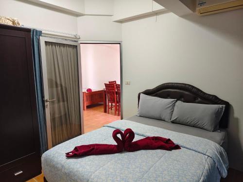a bedroom with a bed with a red ribbon on it at Avatara A Ocean Views by malai in Ban Tha Fat