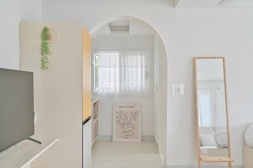 a white hallway with a mirror and a dressing room at 레이니데이 in Namŭm-ni