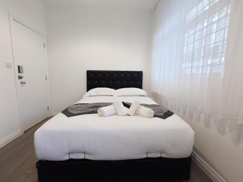 a bedroom with a large white bed with two pillows at Centra Woodgreen in London