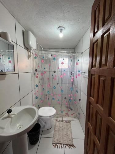 a bathroom with a shower with a toilet and a sink at Pousada Maia in Itaúnas