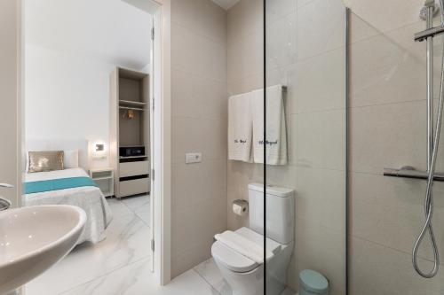 a white bathroom with a toilet and a sink at Ocean View Lanzarote by Beyond in Tías