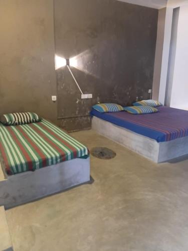 two twin beds in a room withthritisthritisthritisthritisthritisthritisthritisthritisthritis at Ocean beach in Galle