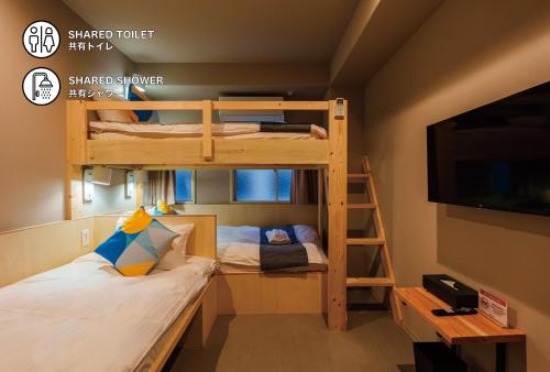a room with bunk beds and a tv and a bed at BAKURO - Doyanen Hotels in Osaka