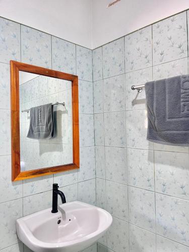 a bathroom with a sink and a mirror and towel at Book Lanta House in Ban Ru Yai