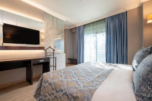 a bedroom with a bed and a desk with a television at 216 Castle Hotel in Gebze