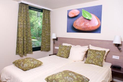 a bedroom with two beds and a picture of fruit at Center Parcs Bispinger Lüneburger Heide in Bispingen