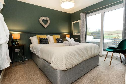 a bedroom with a large bed and a large window at Beth's Bothy in Gatehouse of Fleet