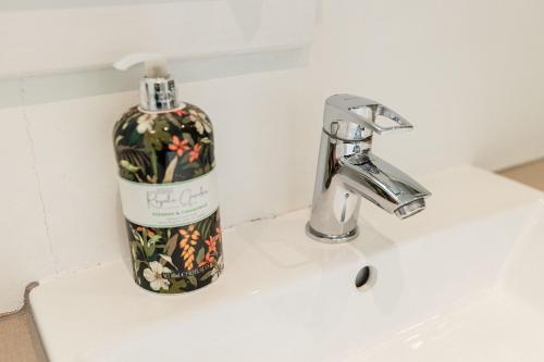 a bottle of soap sitting on a bathroom sink at Beth's Bothy in Gatehouse of Fleet