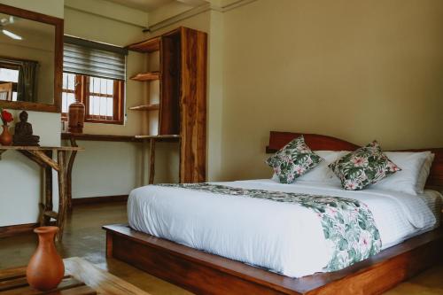 a bedroom with a bed with a white sheets and pillows at The Coconut Experience Eco Lodge Wilpattu in Nagamadu