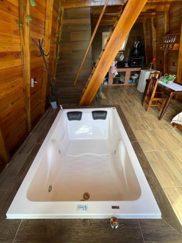 a large white bath tub sitting on the floor of a room at Chalé Fusinato in Witmarsum