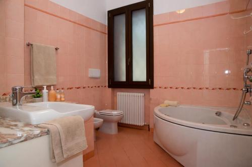 a bathroom with a tub and a toilet and a sink at Corina's Place Bologna Home in Bologna
