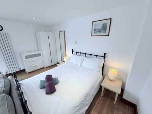 a bedroom with a white bed and a couch at Millbrook House Apartments 9 in Milton