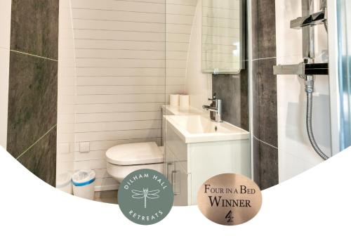 a bathroom with a white toilet and a sink at Dilham Hall Retreats in Dilham