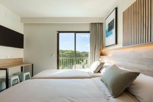 a hotel room with two beds and a window at The Blue Apartments - Adults Only in San Antonio