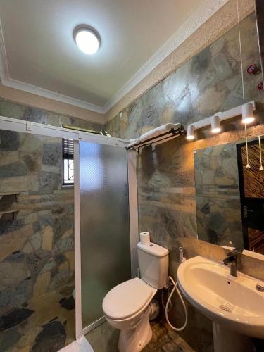 a bathroom with a toilet and a sink at Mawimbi Jiko Hotel in Taveta