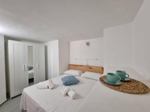 a white bedroom with a bed with a table on it at Tortuga Smeralda in Porto Rotondo