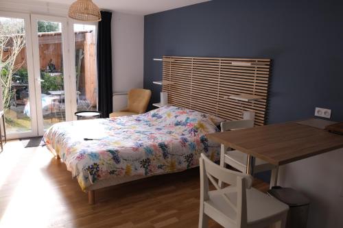 a bedroom with a bed and a desk and a table at Beau studio calme, indépendant avec terrasse in Pessac