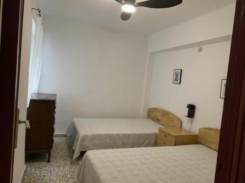 a bedroom with two beds and a ceiling fan at RIU MAR Apartment Cullera in Cullera
