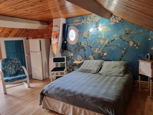 a bedroom with a bed and a blue wall at Chambres à l'Orée du bois in Souancé-au-Perche
