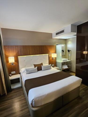 a bedroom with a large bed and a bathroom at Gran Hotel Botánicos in Teruel