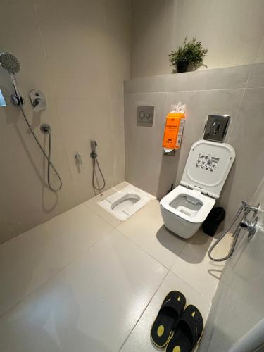 a bathroom with two toilets and a shower with an orange box at شقة رقم 1 in An Najaf