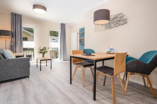 a living room with a table and chairs at Ostsee Apartmenthotel in Graal-Müritz