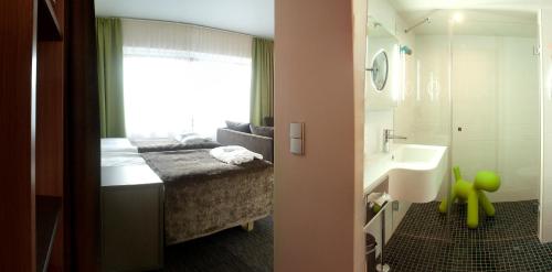 a bedroom with a bed and a sink and a bathroom at Solo Sokos Hotel Lahden Seurahuone in Lahti