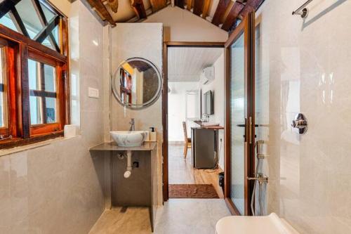 a bathroom with a sink and a mirror at Sea Shades Cottages with Private Jacuzzi in Palolem