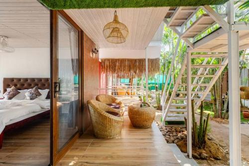 a bedroom with a bed and a ladder and a staircase at Sea Shades Cottages with Private Jacuzzi in Palolem