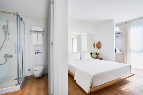 a bedroom with a white bed and a shower at Flamm Residences in Bodrum City