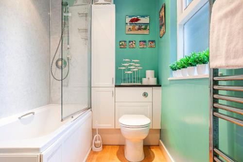a bathroom with a toilet and a glass shower at Stoneywell Cottage - Elie in Elie