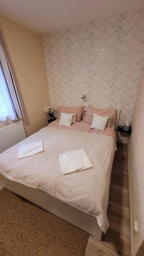 a bedroom with a bed with two towels on it at Harcsa Vendégház Tiszafüred in Tiszafüred