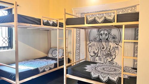 a room with two bunk beds with a mural at GoArize by Rootsvilla Vagator in Anjuna