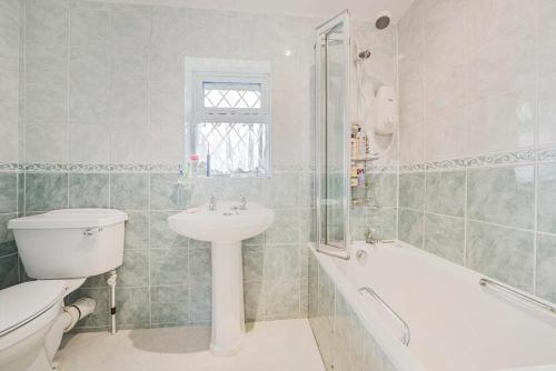a bathroom with a sink and a toilet and a bath tub at The Sweet Spot in Ickenham