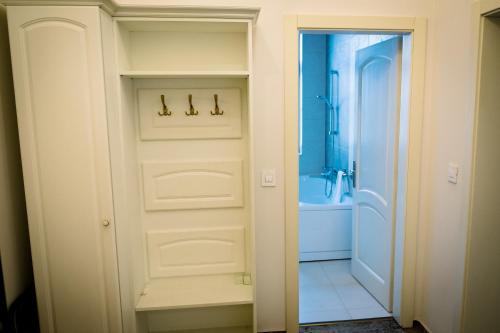 a bathroom with a white door and a tub at Hotel-Restaurant La Belle Epoque in Petroşani