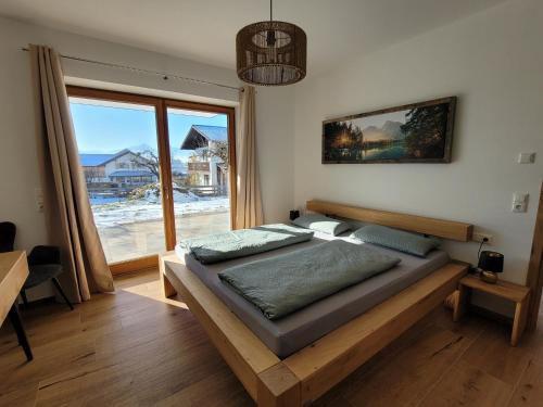 a bedroom with a large bed and a large window at Ferienwohnung Obstgarten in Halblech