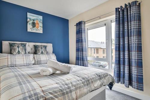 a bedroom with a bed with blue walls and a window at Beautiful City Centre House with Parking! Sleeps 6 in Sheffield