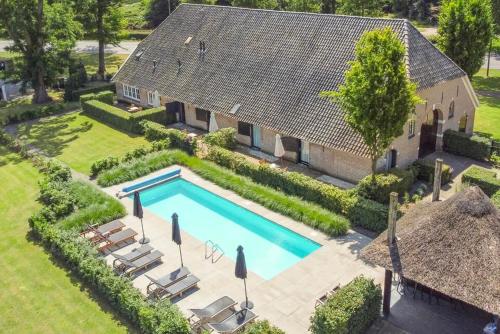 an aerial view of a house with a swimming pool at De Kasteelboerderij in Ruurlo