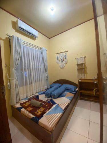 a bedroom with a bed and a window at Sadewa homestay batukaras in Batukaras