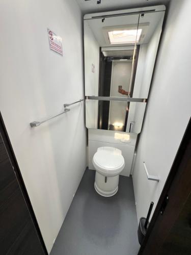 a small bathroom with a toilet and a mirror at Ferienhäuser Insel Usedom - Luxuswohnwagen Doppeltür mit Whirlpool in Lütow