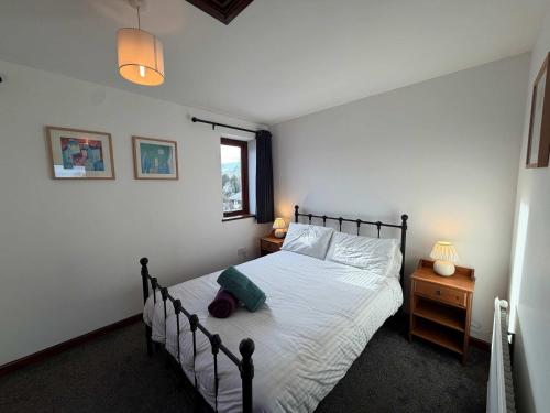 a bedroom with a bed with white sheets and a window at Millbrook House Apartments 3 in Milton