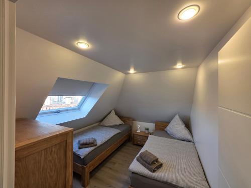 a attic room with two beds and a window at Handwerkerwohnung, Monteurunterkunft-Rodgau in Rodgau